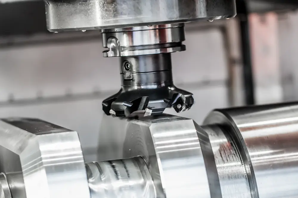 End mill removing material from a Kovar workpiece on a CNC milling machine with visible chips
