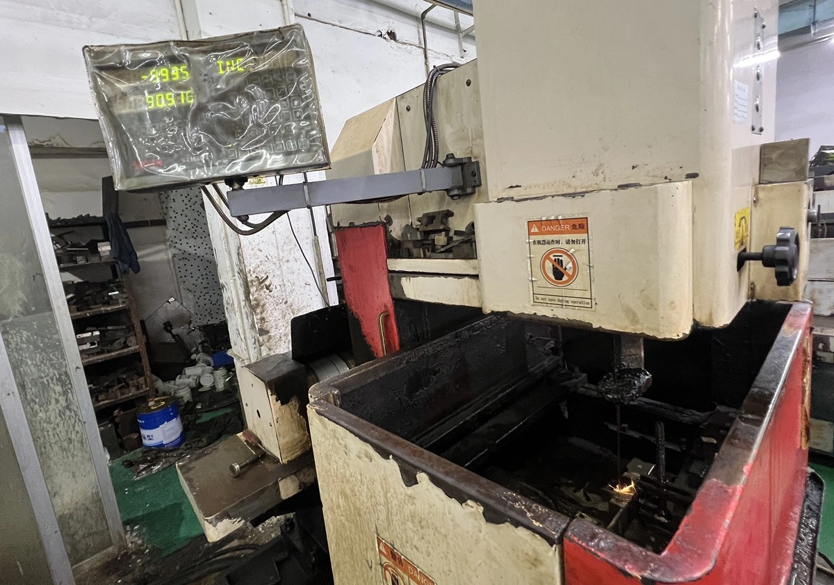 Wire EDM machine cutting conductive metal with sparks underwater