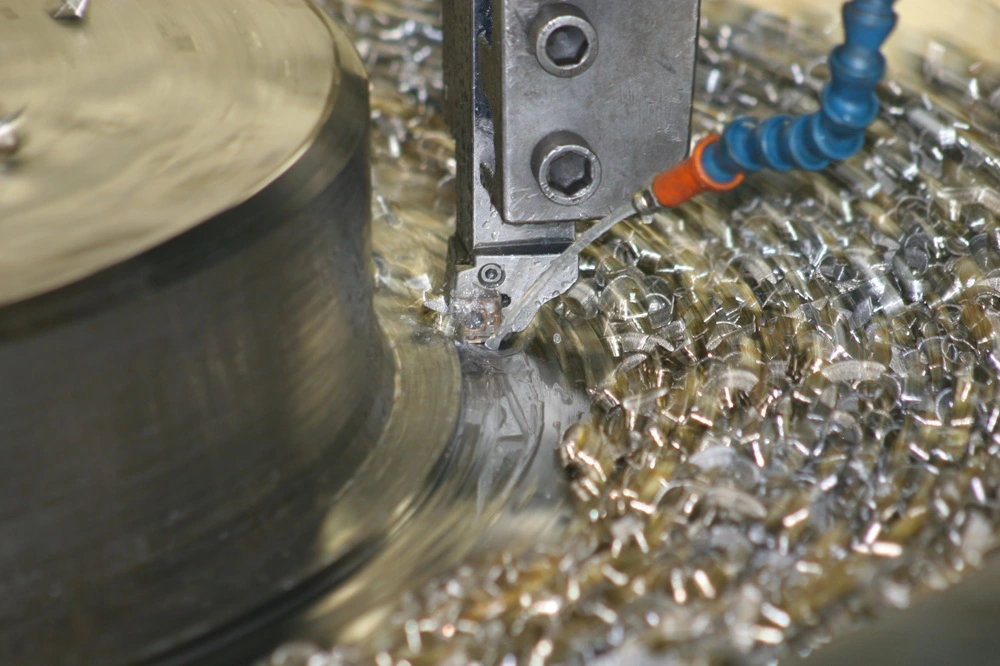 Stringy and gummy chips formed during aluminum bronze CNC machining, highlighting the need for specialized chip control