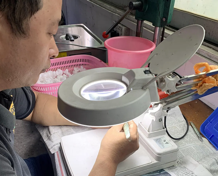 Technician deburring precision machined plastic components