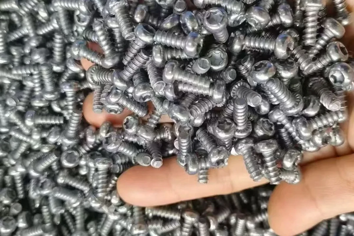 Batch of small silver finished threaded fasteners during handling inspection