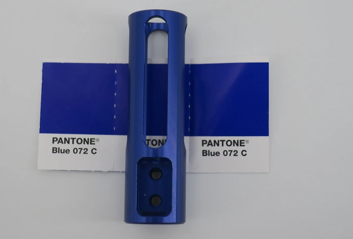 Blue anodized aluminum CNC part positioned against a Pantone Blue 072 C color reference
