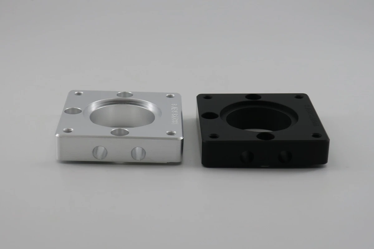 Clear anodized and black anodized aluminum CNC parts shown side by side with matching geometry
