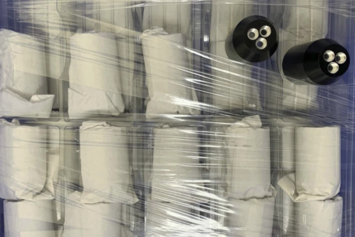 Individually wrapped aluminum turned spool shafts separated with tissue paper before outer packaging