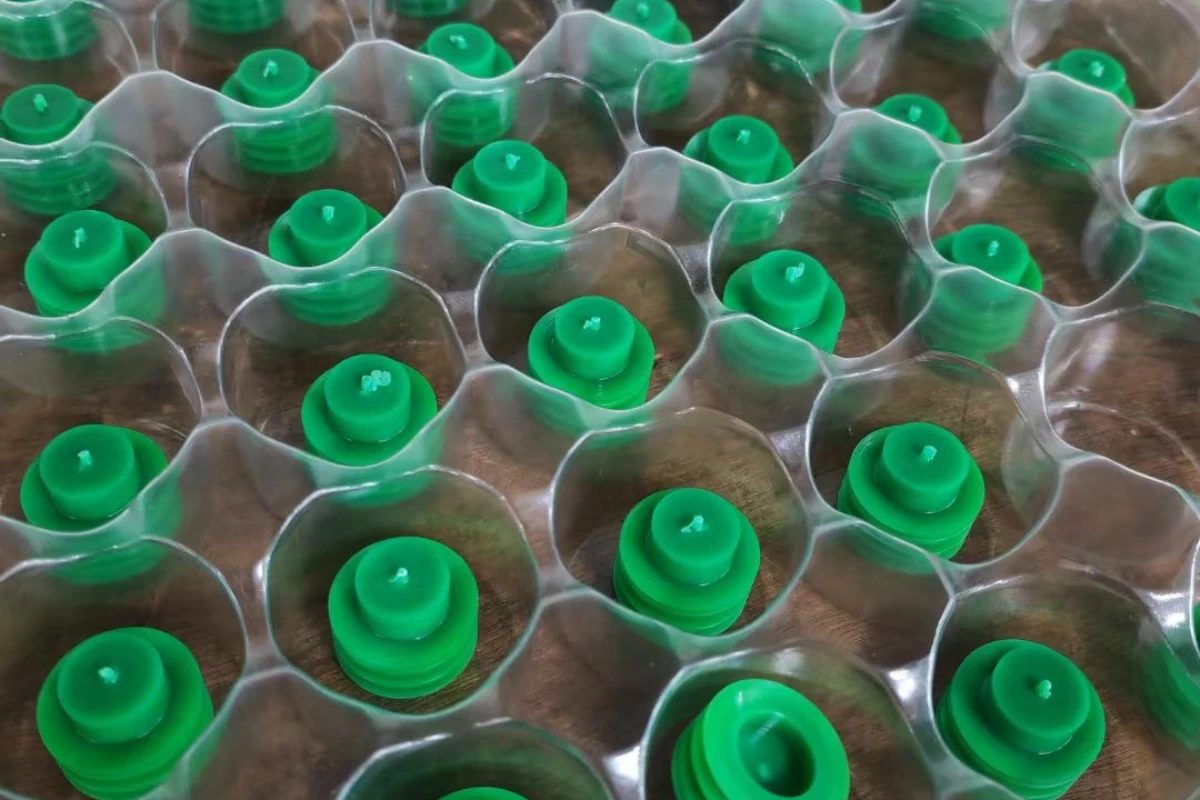 Machined plastic parts protected inside a small rigid blister tray with cushioning