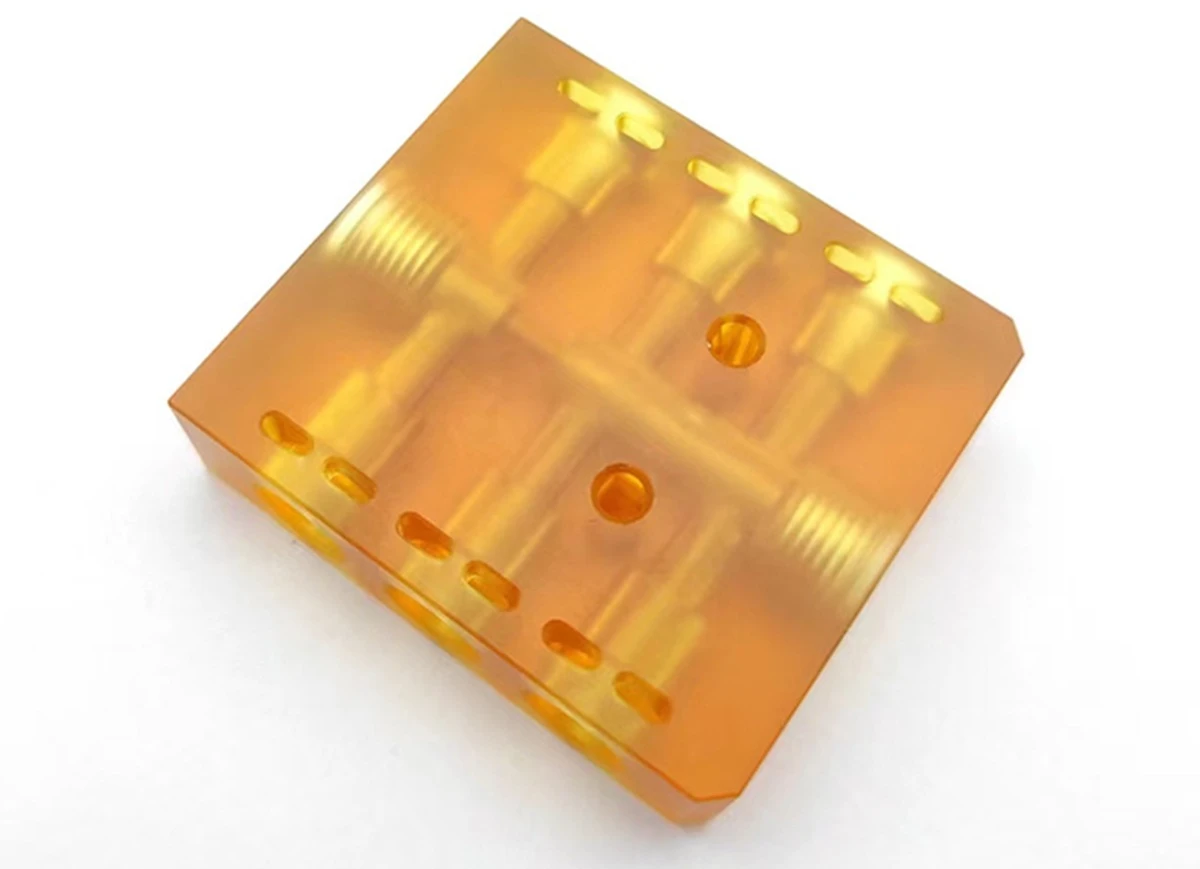 ULTEM 1000 PEI CNC machined block with precision holes and slots.