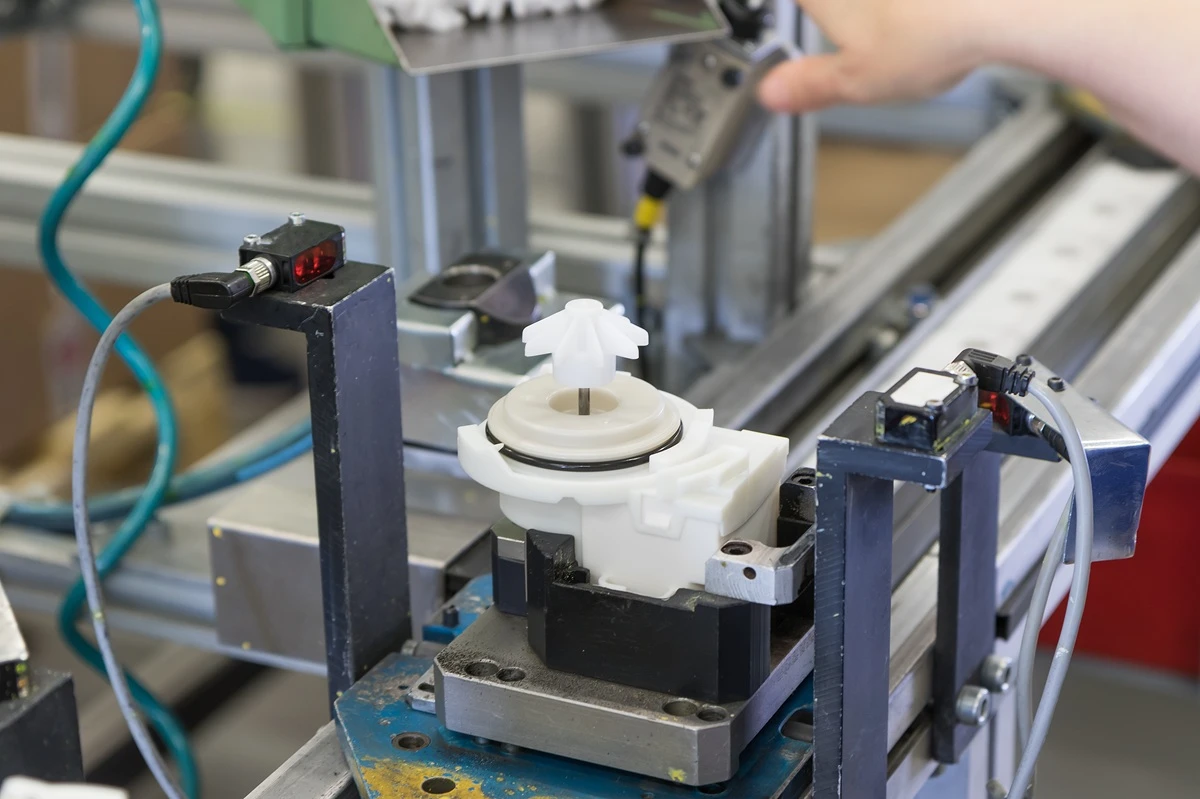 White CNC machined UHMW component installed in an automated assembly and sensor station