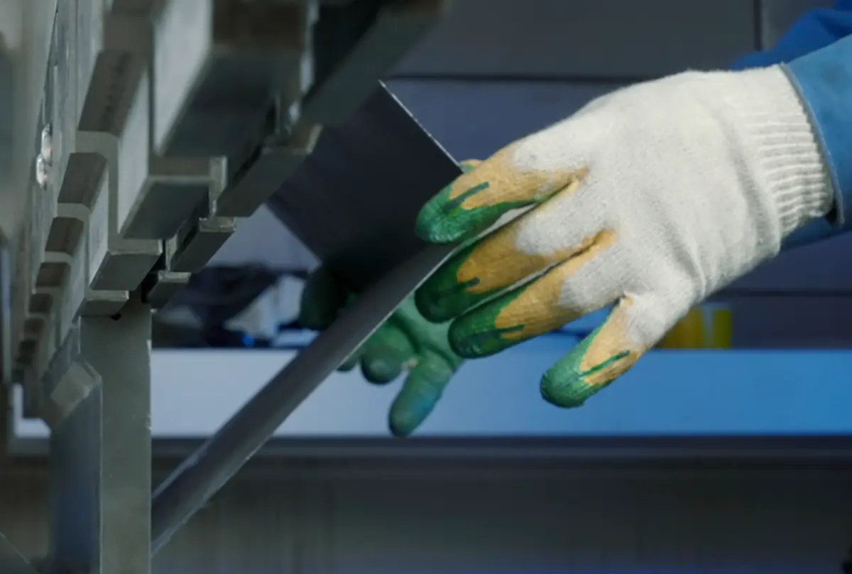 Worker bending sheet metal on a press brake